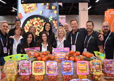 El equipo de Village Farms posa orgulloso junto a una colorida muestra de tomates cultivados en invernadero.