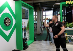 El Aubergenius, alias Dirk van Duijvenbode, jugando a los dardos en el stand de Oerlemans Plastics.